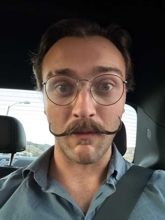 A picture of a young man with a long, curly mustache